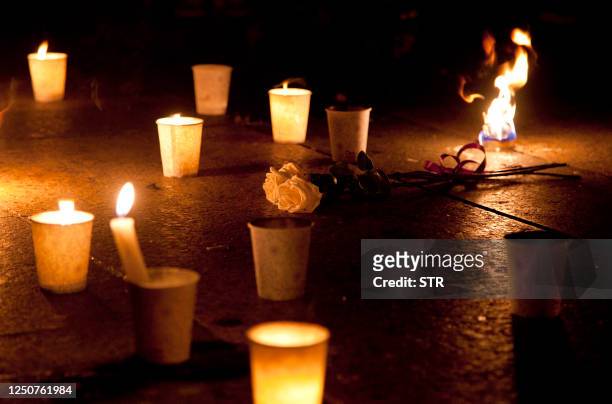 This photo taken on July 25, 2011 shows lit candles and flowers left by mourners for the victims who died in the July 23 high-speed train collision,...