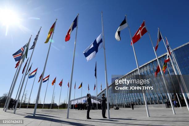 Finnish military personnel install the Finnish national flag at the NATO headquarters in Brussels, on April 4, 2023. - Finland on April 4, 2023...
