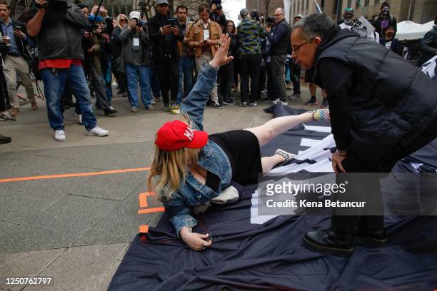 Trump supporter removes a banner from anti-Trump protesters outside the Manhattan Criminal Courthouse on April 04, 2023 in New York City. Former...