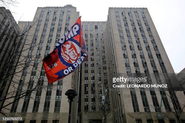 Supporter of former US president Donald Trump holds a flag outside the Manhattan District Attorney's office in New York City on April April 4, 2023....