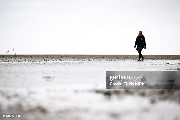 Surfers Against Sewage representative Chani Kind walks on March 30 on Ryde beach, on the Isle of Wight which has suffered from sewage pollution in...