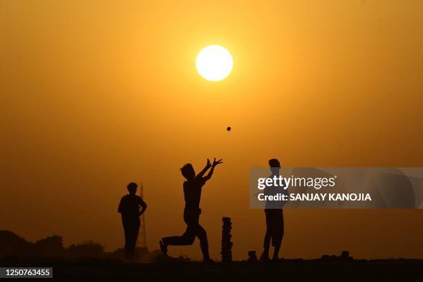 Boys play cricket on the banks of river Ganges in Prayagraj on April 4, 2023.