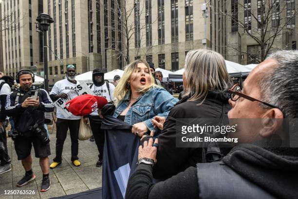 Supporter of former US President Donald Trump, center, and a protestor clash outside criminal court in New York, US, on Tuesday, April 4, 2023....