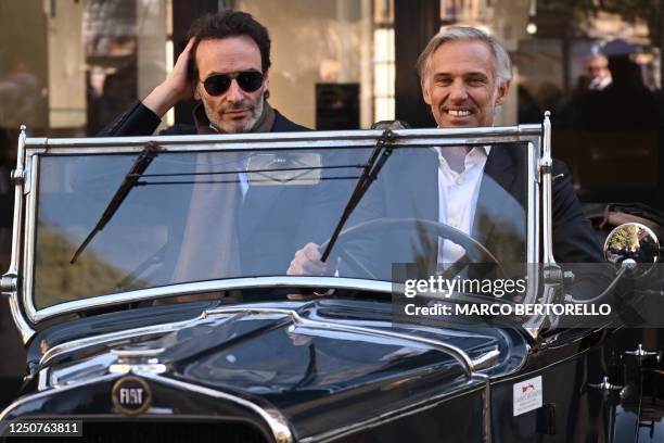 French actors Anthony Delon and Paul Belmondo smile as they ride in a classic car, re-enacting the photo on the poster of the film "Borsalino" in...