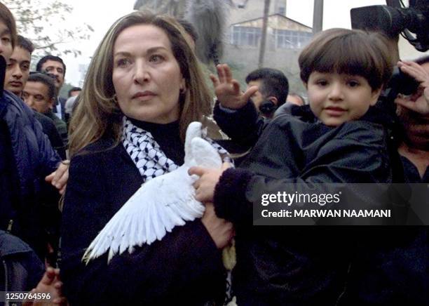 Cairo-based Syrian film star Raghda holds an Iraqi boy and a white dove during a peaceful demonstration outside the United Nations Development...