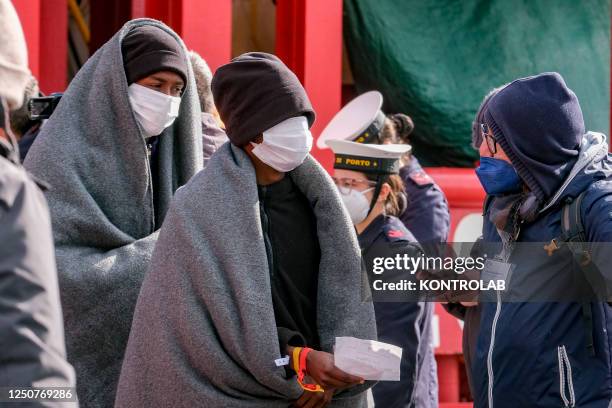 Volunteer gives first assistance to migrants just landed from the NGO SOS Mediterranean Ocean Viking ship that rescued 92 people, including nine...