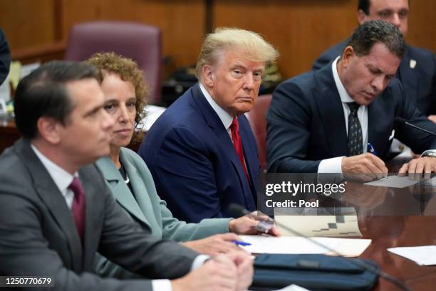 Former U.S. President Donald Trump sits at the defense table with his defense team in a Manhattan court during his arraignment on April 4 in New York...