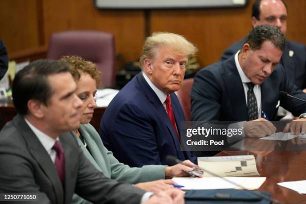 Former U.S. President Donald Trump sits at the defense table with his defense team in a Manhattan court during his arraignment on April 4 in New York...