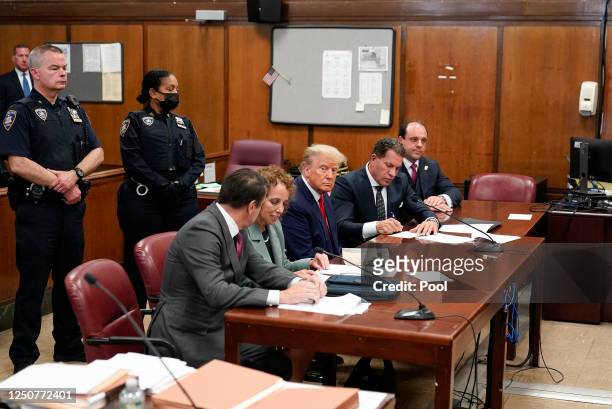 Flanked by attorneys, former U.S. President Donald Trump appears in the courtroom for his arraignment proceeding at Manhattan Criminal Court on April...