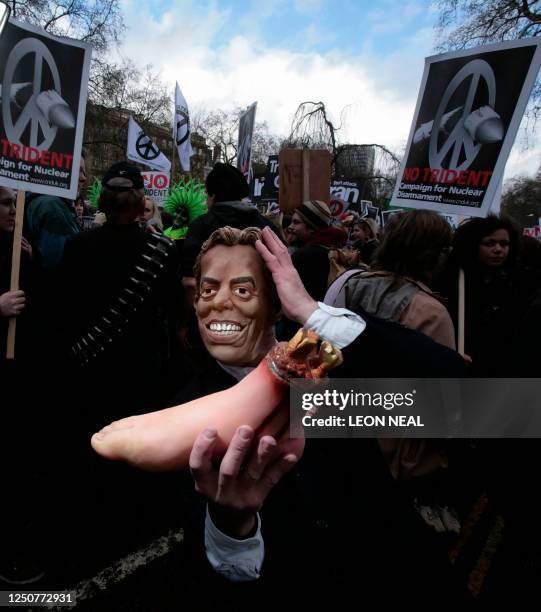 Protester, wearing a mask of British Prime Minister Tony Blair, holds up a plastic severed foot during the Anti-War March through the streets of the...