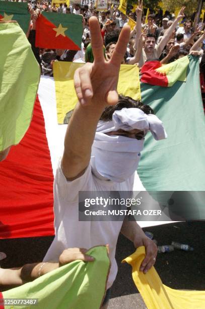 Kurdish men holding portraits of Kurdish jailed rebel leader Abdullah Ocalan and the Kurdish national colours demonstrate for peace and democracy in...