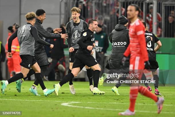 Freiburg players celebrate after winning the German Cup quarter-final football match FC Bayern Munich v SC Freiburg in Munich southern Germany on...