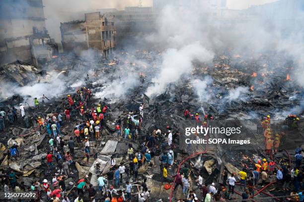 Aerial view of firefighters, rescue workers, local people, and helpers extinguishing a fire at the Bangabazar market in Dhaka. A massive blaze has...