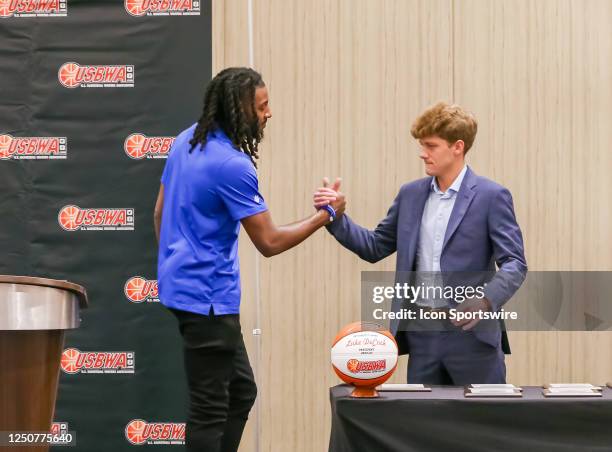 Perry Wallace Most Courageous award winners Terrance Hargrove and Connor Odom shake hands during the USBWA luncheon awards ceremony on April 3, 2023...