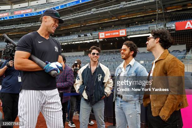 Aaron Judge of the New York Yankees talks to Nick Jonas, Kevin Jonas, and Joe Jonas before the game between the Philadelphia Phillies and the New...