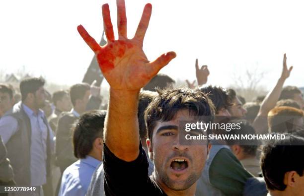 An angry demonstrator shows blood on his hand during riots in the Iraq northern Kurdish town of Halabja, 16 March 2006. A 14-year-old boy was killed...