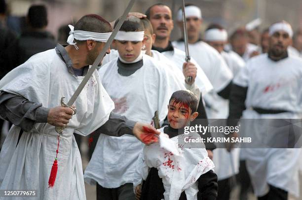 An Iraqi Muslim Shiite use a sword to cut the head of his brother outside Imam Mussa al-Kazem shrine in central Baghdad 19 February 2004 at the peak...