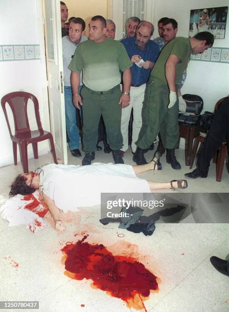 Lebanese forensics stand close to the body of American woman Bony Witheroll as she lies covered on the ground of the missionary clinic prior to being...