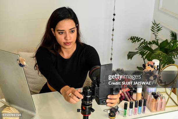 In this photo taken on March 16 social media beauty and lifestyle influencer Debasree Banerjee does her make-up while going live on her YouTube...