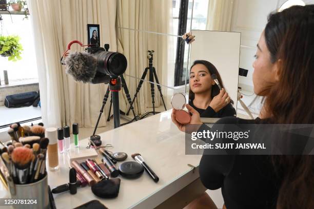 In this photo taken on March 16 social media beauty and lifestyle influencer Debasree Banerjee does her make-up while going live on her YouTube...