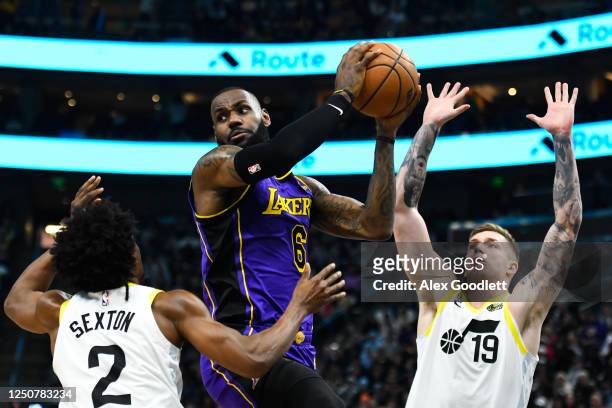 LeBron James of the Los Angeles Lakers looks to pass around Collin Sexton and Luka Samanic of the Utah Jazz during the second half at Vivint Arena on...