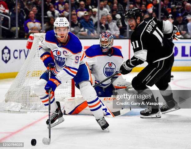 Connor McDavid of the Edmonton Oilers skates with the puck with pressure from Anze Kopitar of the Los Angeles Kings during the third period at...