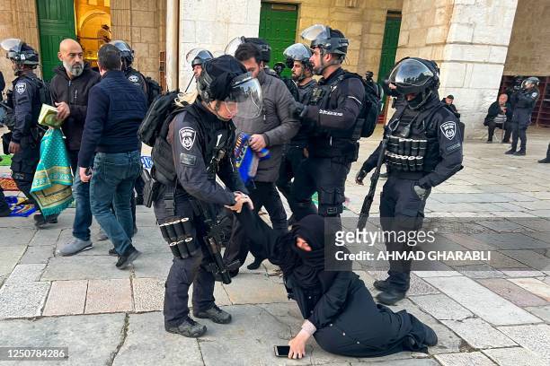 Israeli security forces remove Palestinian Muslim worshippers sitting on the grounds of the Al-Aqsa mosque compound in Jerusalem, early on April 5,...