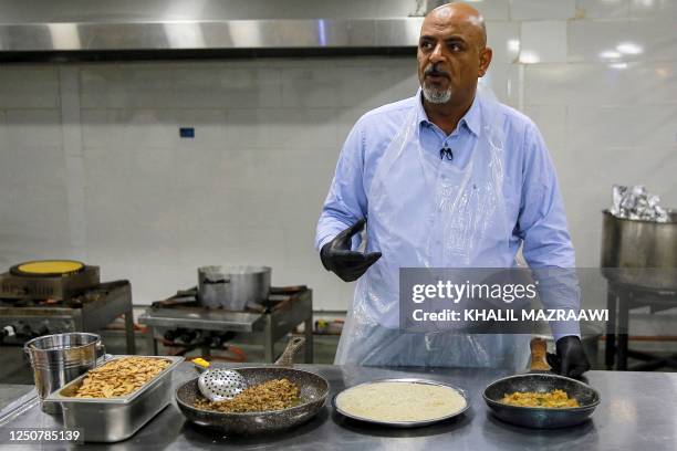 Ashraf al-Mubaideen co-owner of a traditional restaurant specialising in the traditional Jordanian dish "Mansaf" , speaks as he prepares a meal at...