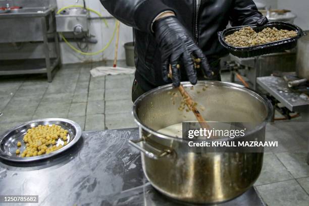 Tamer Majal, co-owner co-owner of a traditional restaurant, speaks as he cooks a pot of "Rashouf" , at the kitchen in Amman on March 16, 2023. - The...