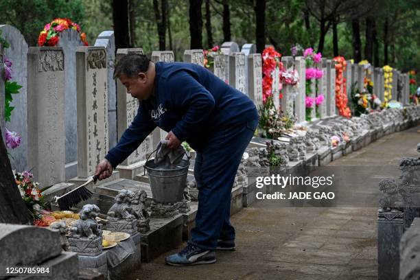 Man sweeps a tomb of deceased relatives during the annual Tomb-Sweeping festival, also known as the Qingming festival, at Babaoshan Cemetery in...