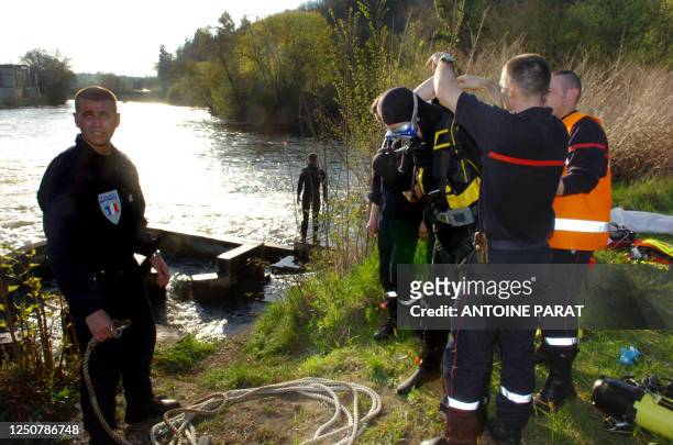 Des policiers et des pompiers s'affairent, le 21 avril 2006 sur les berges de la Vienne près de Limoges, où un homme de 44 ans et ses deux fils de 9...