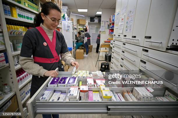 Pharmacy worker opens a drawer full of drugs in a pharmacy in Colomiers, southwestern France, on March 23, 2023.