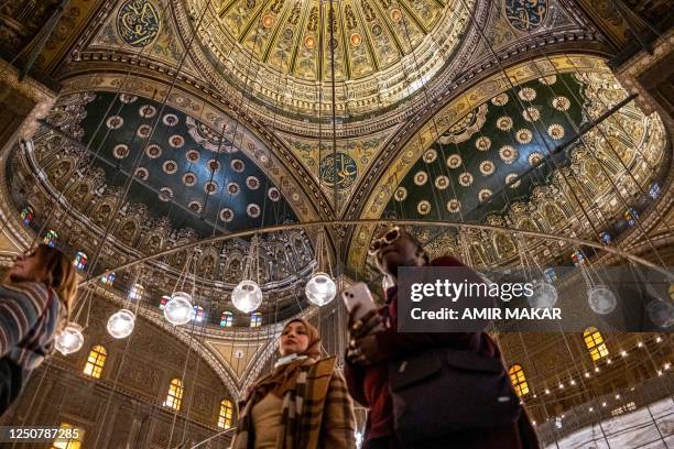 In this picture taken on February 9, 2023 visitors walk inside the 19th century Mosque of Mohamed Ali in the Cairo Citadel.