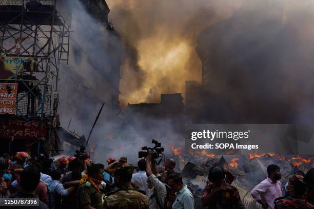 Firefighters and local people try to extinguish a fire that broke out in Bangabazar Market in Dhaka. The fire that took place in Dhaka's Bangabazar...