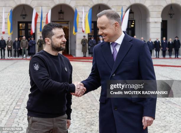 Ukraine's President Volodymyr Zelensky and Polish President Andrzej Duda shake hands during a welcoming ceremony in front of the presidential palace...