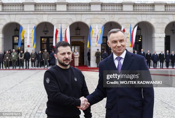 Ukraine's President Volodymyr Zelensky and Polish President Andrzej Duda shake hands during a welcoming ceremony in front of the presidential palace...