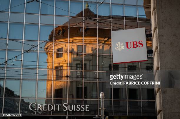 Signs of Swiss bank giant UBS bank is seen next to a sign of Credit Suisse baking in Basel, on April 4, 2023 on the eve of the general meeting of...