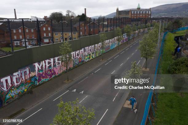 Local resident walks along the so called peace wall on April 3, 2023 in Belfast, Northern Ireland. The Good Friday Agreement, signed on April 10...