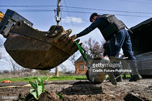 Mine clearance expert attaches a FAB-500 air-dropped bomb to the bucket of an excavator in Orikhiv, Zaporizhzhia Region, southeastern Ukraine.