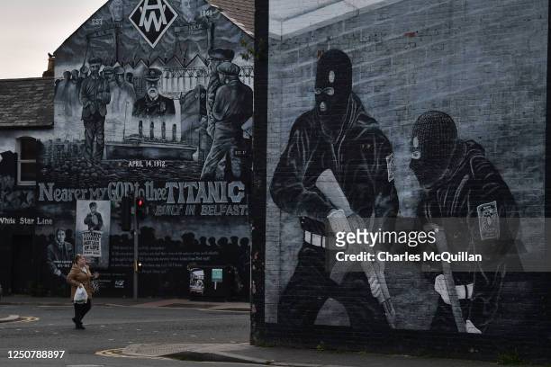 Local resident walks past a loyalist paramilitary mural on April 4, 2023 in Belfast, Northern Ireland. The Good Friday Agreement, signed on April 10...