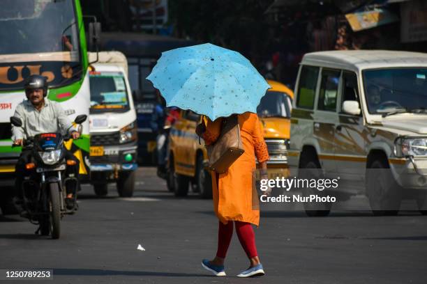 People are seen carrying umbrella to escape from summer heat in Kolkata , India , on 5 April 2023 .