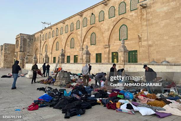 Palestinians look for their belongings following clashes inside Jerusalem's Al-Aqsa mosque early on April 5, 2023 during the Muslim holy month of...