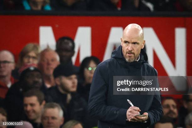 Manchester United's Dutch manager Erik ten Hag takes notes during the English Premier League football match between Manchester United and Brentford...