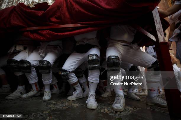 Penitents called costaleros under the image of the Virgin Mary of Rosario Brotherhood in a crowded square during de Holy Wednesday in Granada, Spain...