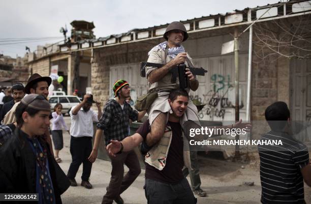 Israeli settlers dressed in costumes as they celebrate the annual Purim parade in the divided West Bank city of Hebron on March 20, 2011. Purim...