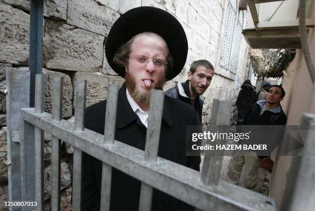 An Ultra-Orthodox Jewish man flashes his tongue as he stands at a Palestinian house where he visits with fellow believers and setters the Jewish...