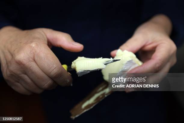 Stacey Hedges, Owner and Founder of Hampshire Cheese Company cuts a Tunworth cheese to sample at the Hampshire Cheese Company near Basingstoke in...