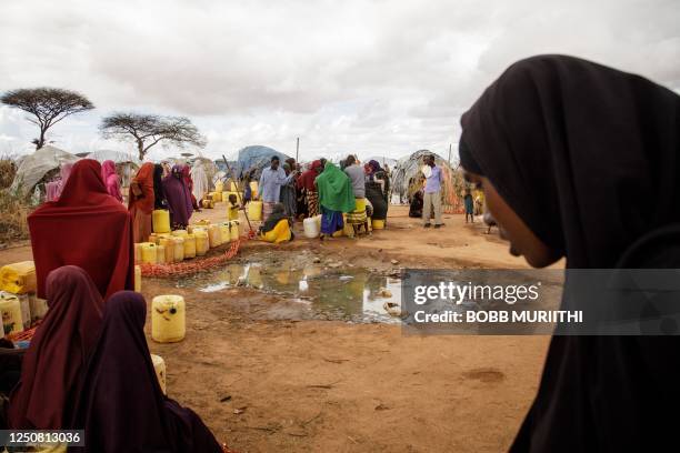 Somali refugees put water containers for the water distribution by French charity Doctors Without Borders in the Dadaab refugee camp, one of Africa's...