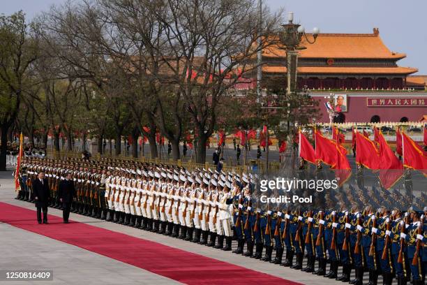 French President Emmanuel Macron inspects an honor guard with Chinese President Xi Jinping during a welcome ceremony outside the Great Hall of the...