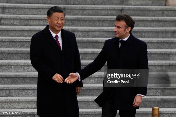 French President Emmanuel Macron prepares to shake hands with Chinese President Xi Jinping during a welcome ceremony outside the Great Hall of the...